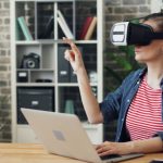 VR Displays - A woman wearing a virtual reality headset sitting at a desk