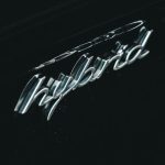 Power Consumption - From above of contemporary black hybrid auto with creative title and water droplets on surface