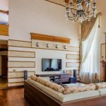 8K TV - A large living room with wooden floors and a chandelier