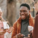 Smartphone Resolutions - Laughing diverse friends with smartphones in park