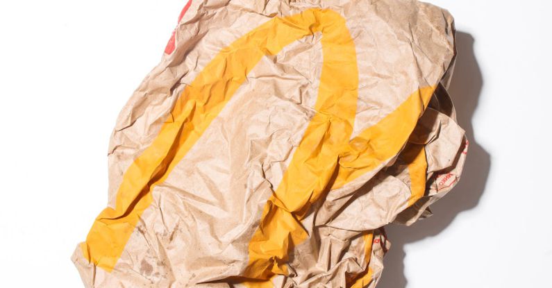 Response Times - Top view of crumpled empty craft paper bag of fast food restaurant placed on white background illustrating recycle garbage concept