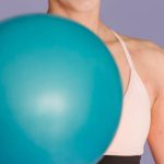 Ultra-Short Throw - Happy sportive woman exercising with ball