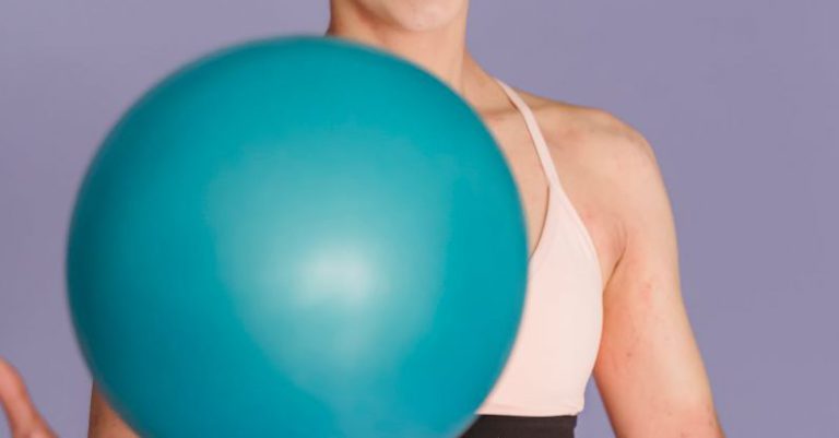 Ultra-Short Throw - Happy sportive woman exercising with ball