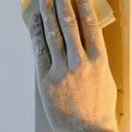 Color Accuracy - Crop faceless person grinding wall with sandpaper during renovation