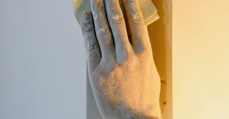 Color Accuracy - Crop faceless person grinding wall with sandpaper during renovation