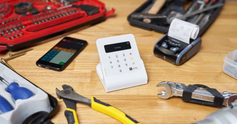 Screen Maintenance - Red and black toolboxes next to smartphone and modern cash registers composing with pliers and wrenches on beige wooden table in bright room